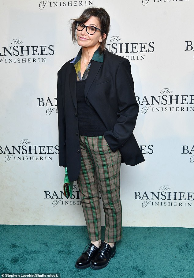 Gina's look: Gina Gershon wore a black shirt and coat and green plaid pants to the Banshees of Inisherin screening